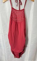 Front view of maroon one-piece swimsuit showing crochet mesh panel and tie straps