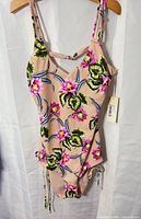 Front view of floral one-piece swimsuit showing pattern, straps, cutout and tag