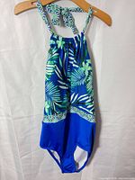 Front of blue/green tropical print one-piece swimsuit on hanger