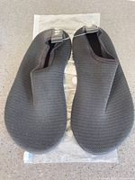 Top view of both black Joto water shoes on packaging