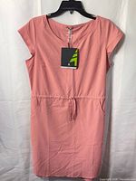Front view of pink Woods dress on hanger showing tag and drawstring waist
