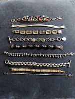 All nine bracelets laid out to show variety, materials and condition
