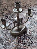 Front view of three-arm brass candelabra