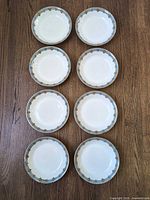 Eight matching rimmed soup bowls laid out to show complete set