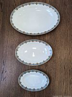 Three graduated oval platters displayed separately