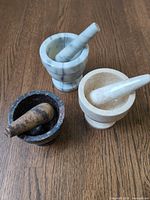 Three mortar and pestle sets standing upright