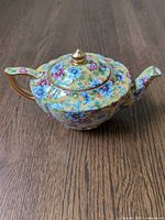 Top and side view of floral teapot showing pattern, lid and spout