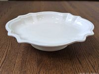 Side view showing scalloped rim and pedestal base