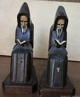 Front view of both wooden monk bookends showing carved and painted details