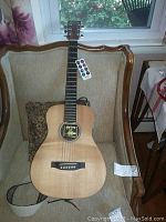 Full front view of Little Martin LX1 guitar on chair