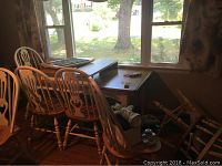 Photo of the table and chairs near a window, shows table top surface and chairs.