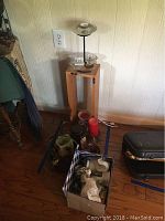 Full view of the lot showing two Bath & Body Works electric wall warmers on a wooden stand and floor, assorted candles and holders in front.