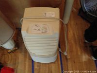 Front view of white Whirlpool dehumidifier showing vented air intake and top control panel with knob.