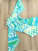 Dress laid flat showing full scarf sleeves and geometric print