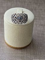 Front view of ring showing heart with blue stones and surrounding clear stone clusters