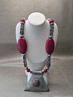 Full view of necklace on bust showing bead arrangement and pendant