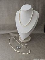 Full lot view showing necklace on bust, second view of necklace laid flat, earrings and brooch