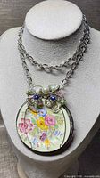 Close view of porcelain pendant with wire wrap and bead accents