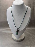 Full view of necklace displayed on bust showing pendant and cord length