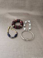 All four bracelets laid out on fabric background