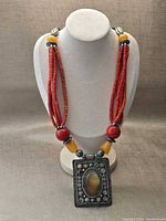 Full view of necklace on bust showing bead strands, spacer beads and pendant