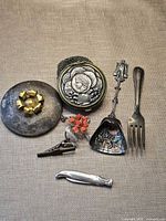Overview of all seven vintage metal items on fabric background