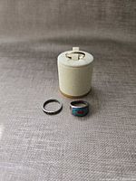 All three rings together: gold-tone on stand, silver-tone plain band, turquoise mosaic ring