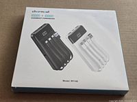 Front of sealed Charmast W1148 box showing two power banks and specs