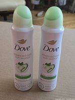 Front view of two unopened Dove Advanced Care Dry Spray cans