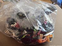 Front view of clear bag showing assorted LEGO bricks and parts