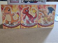 Front view of three Topps Pokemon cards #04 Charmander, #05 Charmeleon, #06 Charizard