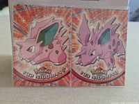 Front view of both Topps Pokémon cards #32 Nidoran ♂ and #33 Nidorino side by side in sleeves