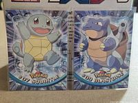 Both Topps Pokémon cards (#07 Squirtle and #09 Blastoise) in sleeves side by side