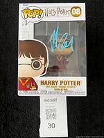 Front of boxed Funko Pop showing autograph and MaxSold lot card