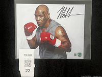 Front view of signed 8x10 photo in sleeve with lot ticket visible