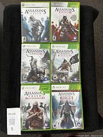 All six Xbox 360 Assassin's Creed game cases displayed