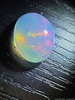 Top view of oval opal cabochon showing play-of-colour