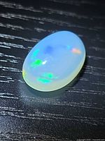 Top view showing oval cabochon shape and play of colour