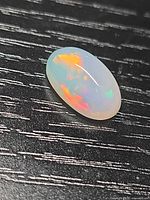 Top view of oval Ethiopian crystal opal displaying multi-colour flashes