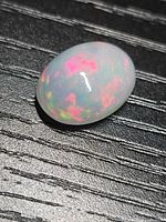 Oval crystal jelly fire opal cabochon showing multi-colour play