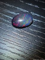 Top view of oval Ethiopian black opal showing multicolor play of color