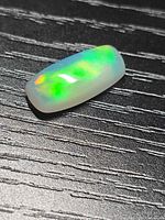 Jelly opal on black surface showing play-of-color