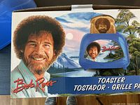 Retail box showing Bob Ross toaster and toast with Bob Ross silhouette