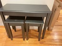 Front view of console table with two stools nested beneath