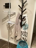 Overall view showing towels, shower curtain on hanger, teal hamper, pole shower caddy