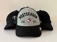 Three caps front view highlighting Blue Jays Postseason cap and placement of other two