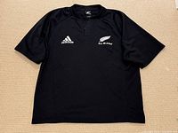Full front view of black Adidas All Blacks rugby jersey