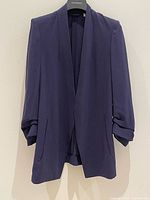 Front view of navy Babaton blazer showing drape lapel and ruched sleeves