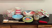 Full group of ceramic, glass, textile and utensil pieces on table