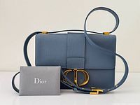 Front view of blue Dior 30 Montaigne bag with CD clasp and COA envelope